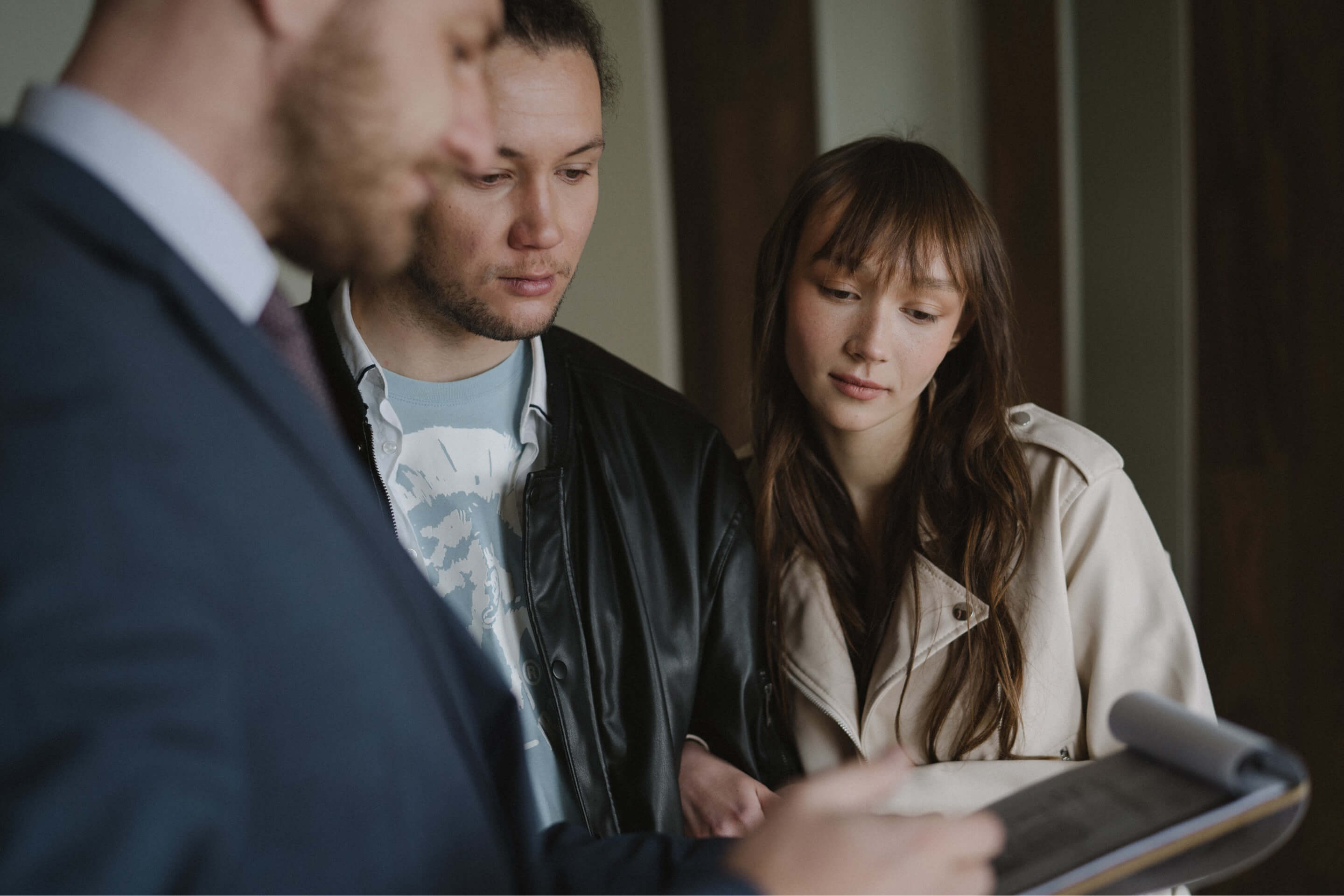 3 people looking at a clipboard interacting with each other